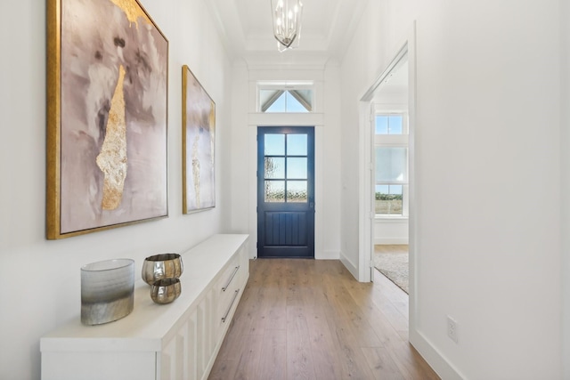 entrance foyer with light wood-style floors, crown molding, and baseboards