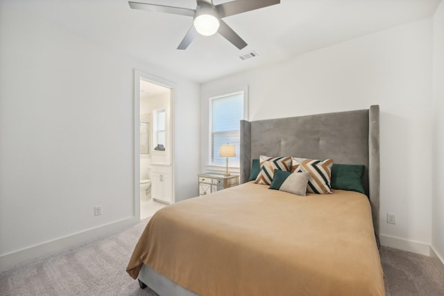 carpeted bedroom with visible vents, ceiling fan, baseboards, and ensuite bathroom