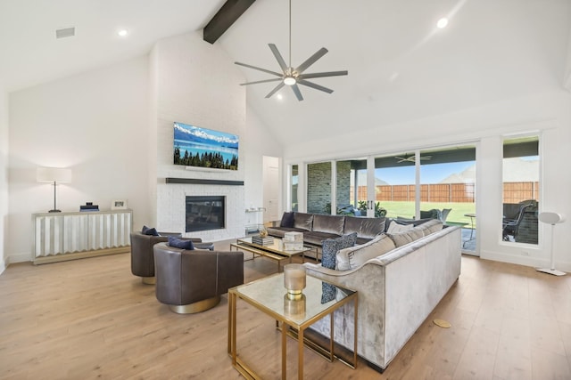 living room featuring beamed ceiling, light hardwood / wood-style floors, a fireplace, and high vaulted ceiling