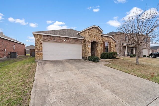 view of front of property featuring cooling unit, a garage, driveway, stone siding, and a front yard