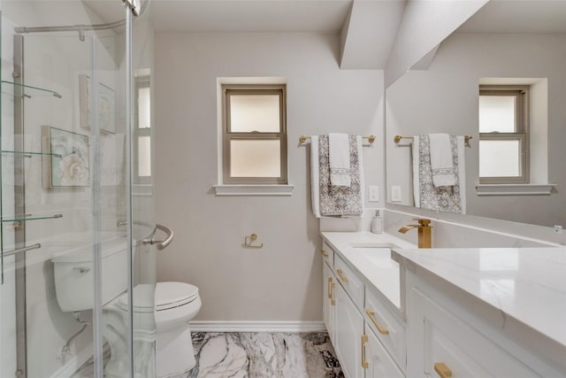 bathroom featuring vanity, toilet, and a shower with shower door