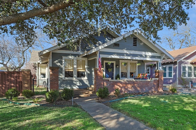 craftsman-style house featuring covered porch and a front lawn