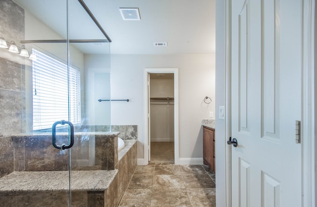 bathroom with vanity and shower with separate bathtub