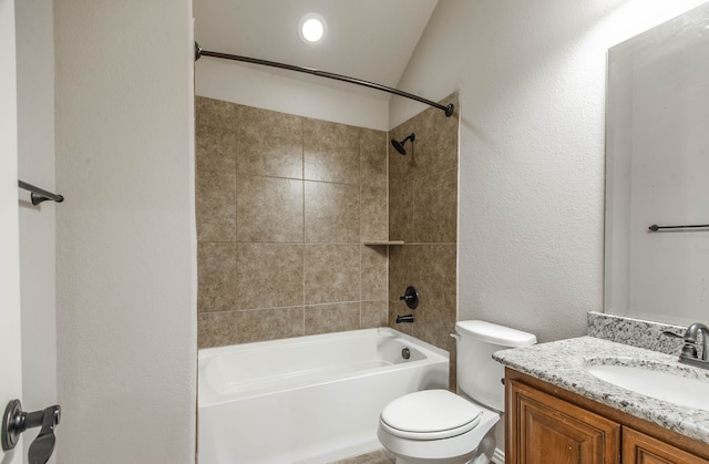 full bathroom featuring tiled shower / bath combo, toilet, and vanity