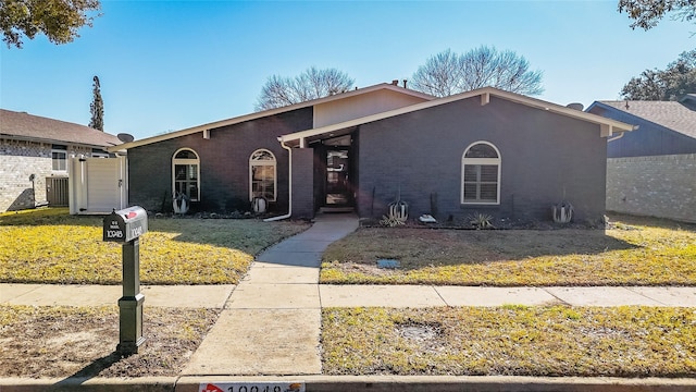 ranch-style home with cooling unit and a front lawn