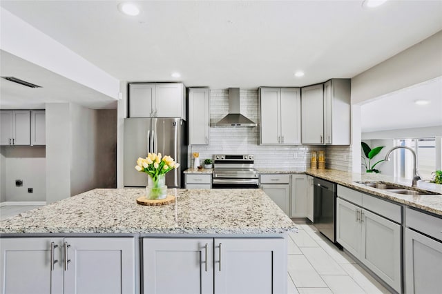 kitchen with backsplash, gray cabinetry, wall chimney range hood, and appliances with stainless steel finishes