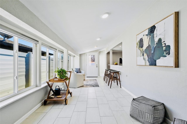 sunroom / solarium with sink and vaulted ceiling