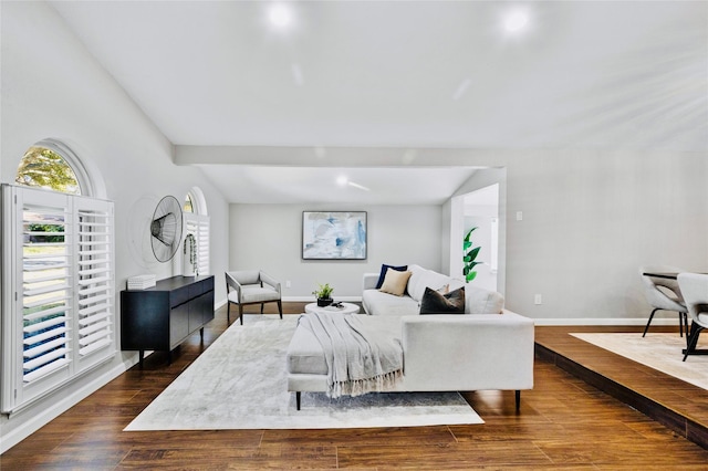 living room featuring wood-type flooring and vaulted ceiling with beams