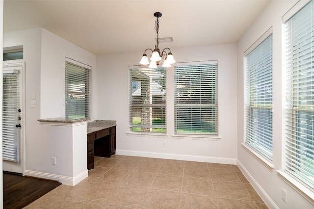 unfurnished dining area featuring a chandelier and light tile patterned floors