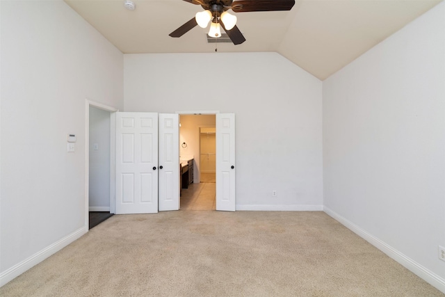 unfurnished bedroom featuring ceiling fan, light colored carpet, and vaulted ceiling