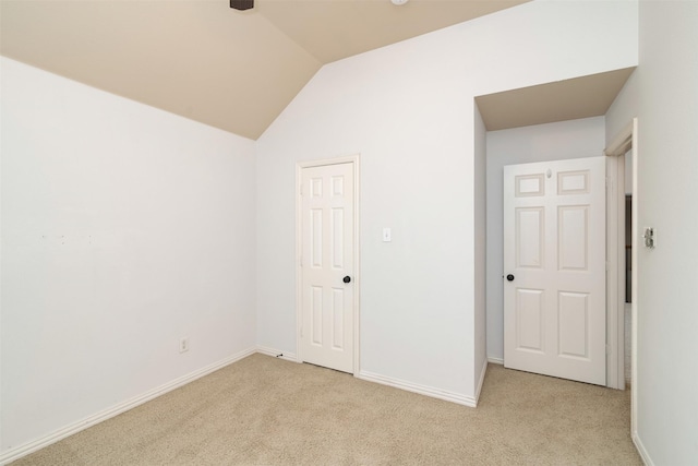 empty room with light colored carpet and lofted ceiling