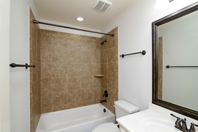 full bathroom featuring toilet, tiled shower / bath, and vanity