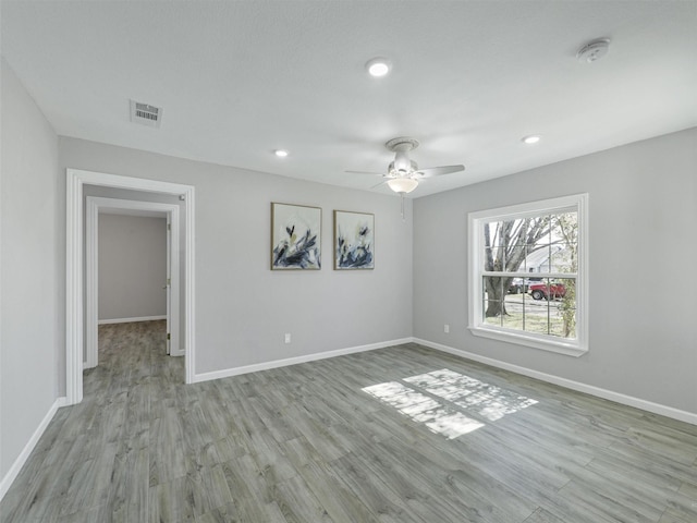 empty room with ceiling fan and light wood-type flooring