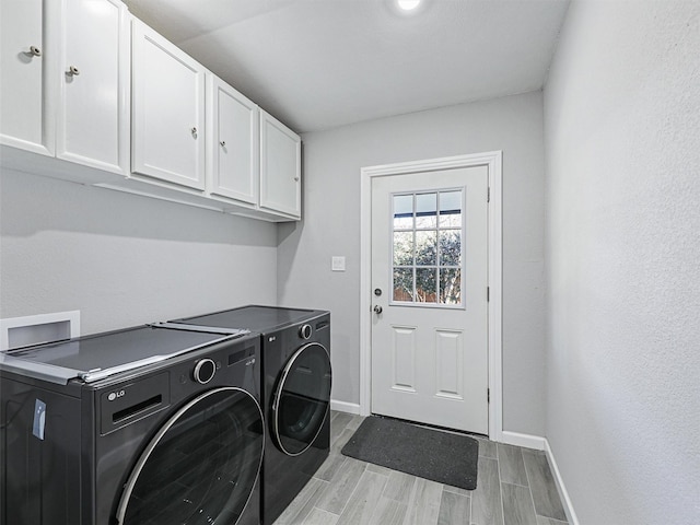 laundry room with light wood-type flooring, cabinets, and independent washer and dryer