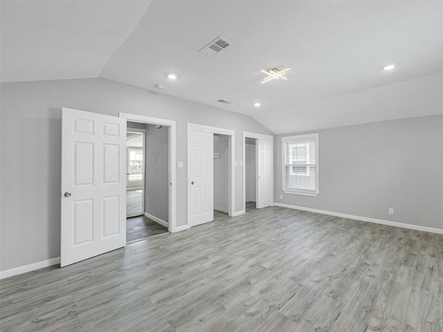 unfurnished bedroom with light hardwood / wood-style flooring and vaulted ceiling