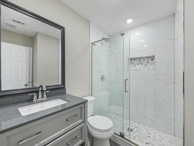 bathroom featuring vanity, toilet, and a shower with shower door