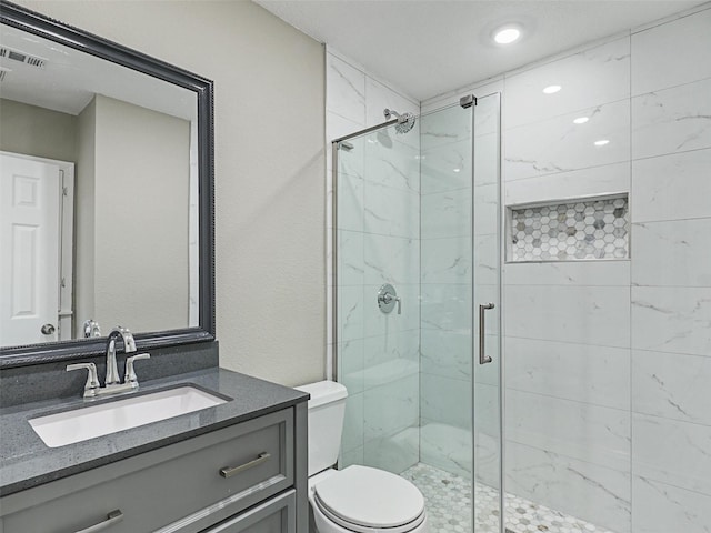 bathroom with an enclosed shower, vanity, and toilet