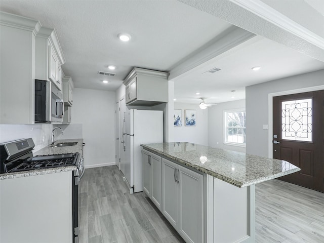 kitchen featuring light stone countertops, sink, white cabinetry, and stainless steel appliances