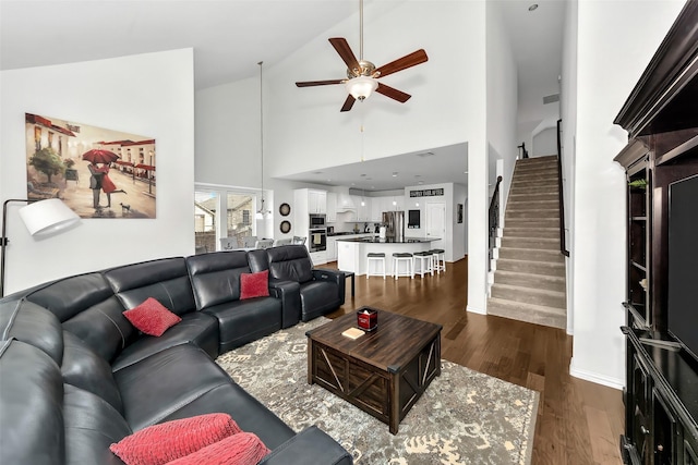 living room with ceiling fan, dark wood-type flooring, and high vaulted ceiling