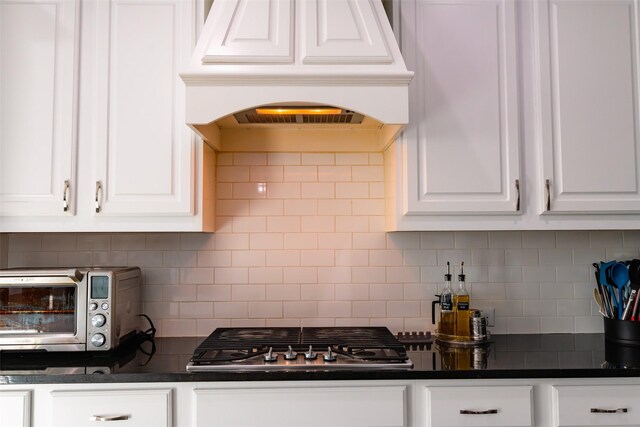 kitchen featuring custom exhaust hood, white cabinetry, and a kitchen island