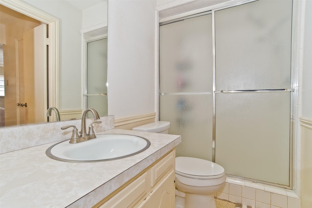 bathroom with vanity, a shower with shower door, and toilet