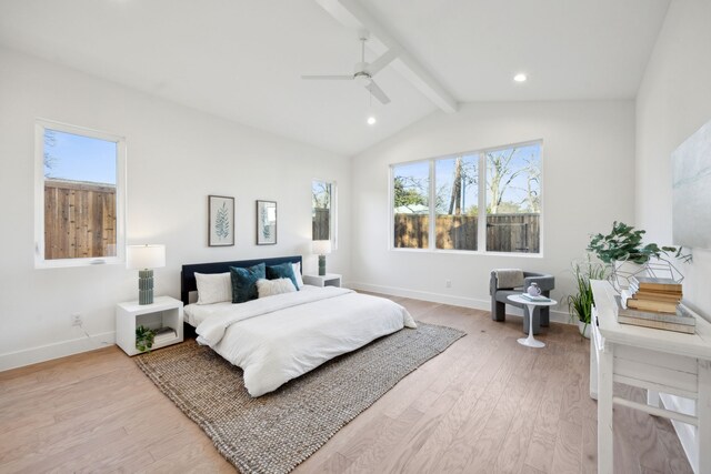 bedroom featuring multiple windows, lofted ceiling with beams, and ceiling fan