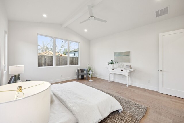 bedroom featuring light hardwood / wood-style flooring, vaulted ceiling with beams, and ceiling fan