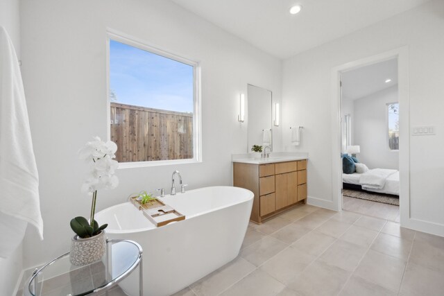 bathroom with a tub and vanity