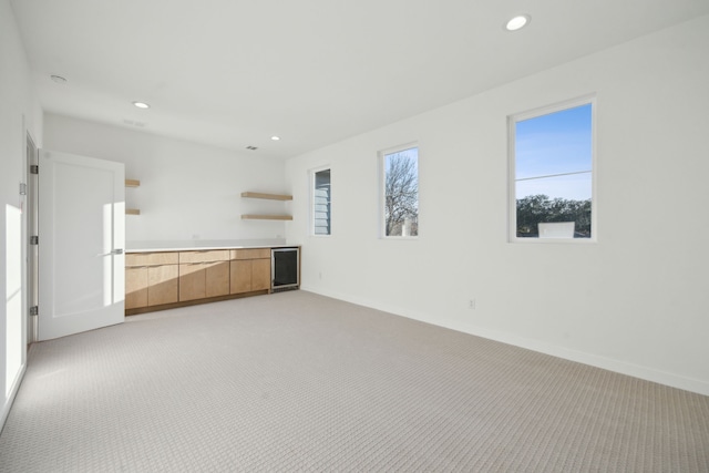 410 Kirkwood Dr, Dallas, TX 75218 - unfurnished living room featuring light carpet, recessed lighting, wine cooler, and bar area
