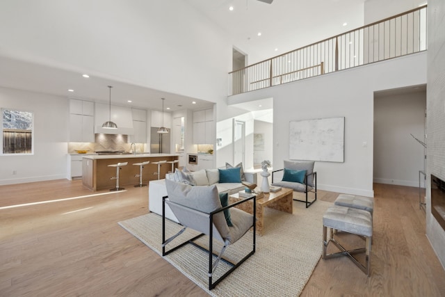 410 Kirkwood Dr, Dallas, TX 75218 - living room featuring light wood-style floors, a towering ceiling, a large fireplace, and recessed lighting