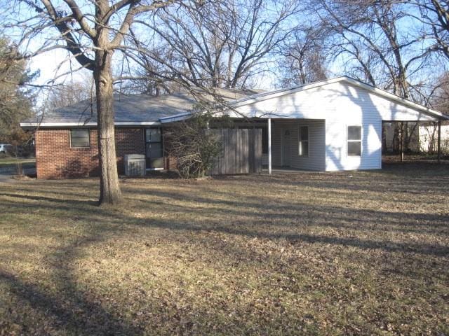 rear view of property with a yard and a carport