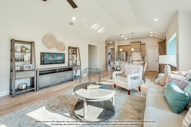 living room with ceiling fan, light hardwood / wood-style floors, and lofted ceiling