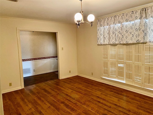 empty room with dark hardwood / wood-style flooring, crown molding, and an inviting chandelier