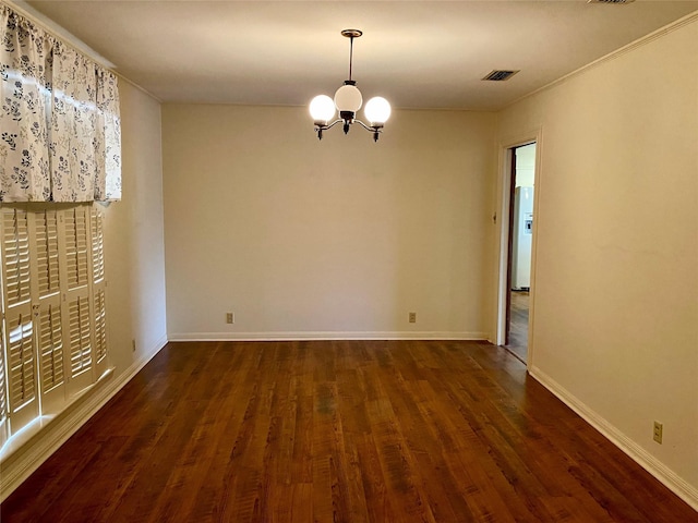 empty room featuring dark hardwood / wood-style flooring and a chandelier