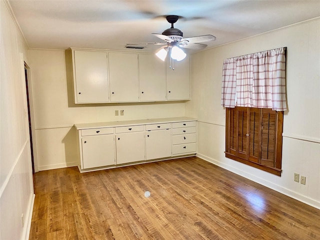 kitchen with ceiling fan, white cabinetry, crown molding, and light wood-type flooring