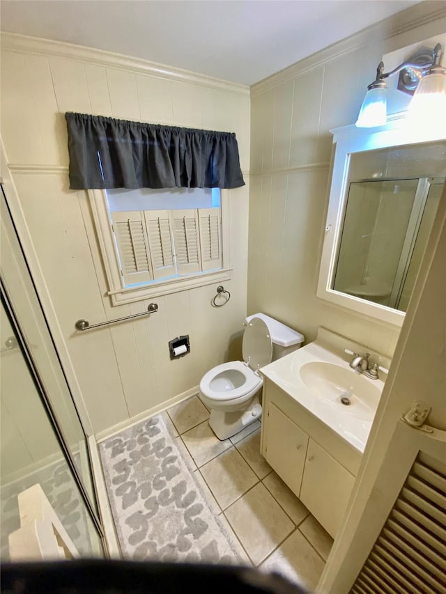 bathroom with tile patterned flooring, toilet, walk in shower, vanity, and ornamental molding