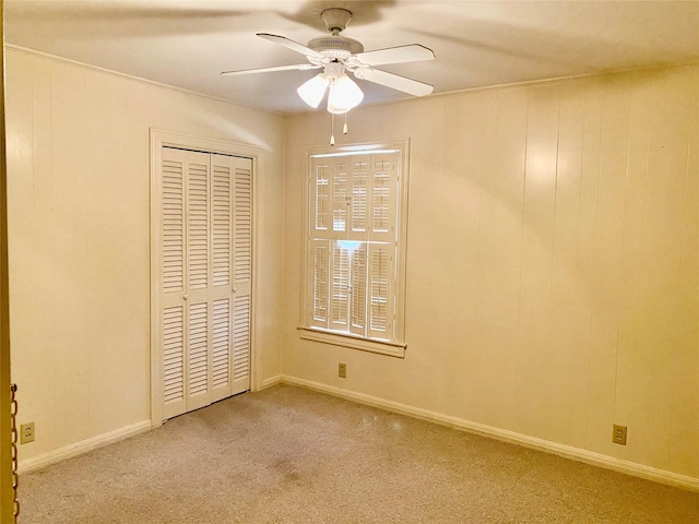 unfurnished bedroom with light colored carpet, a closet, and ceiling fan