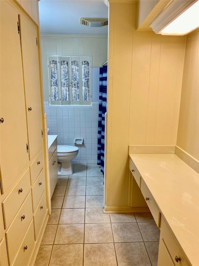 bathroom featuring vanity, toilet, tile walls, and tile patterned flooring