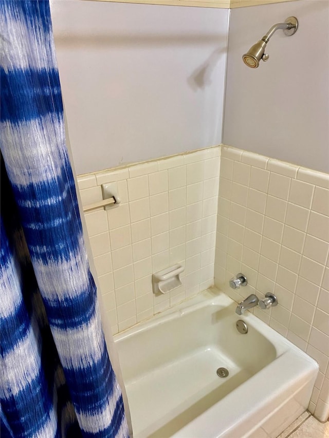 bathroom with a washtub and tile patterned flooring