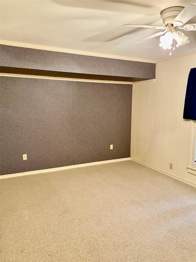 carpeted spare room featuring ceiling fan and ornamental molding