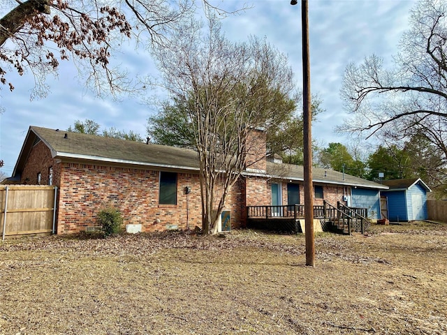 back of house featuring a deck and a shed