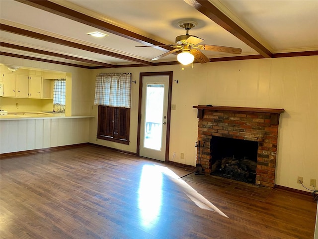 unfurnished living room with dark wood-type flooring, beamed ceiling, ceiling fan, sink, and a brick fireplace