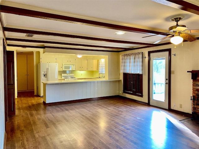 unfurnished living room with sink, ceiling fan, beam ceiling, and dark wood-type flooring