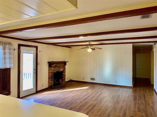 unfurnished living room with ceiling fan, hardwood / wood-style floors, beamed ceiling, and a fireplace