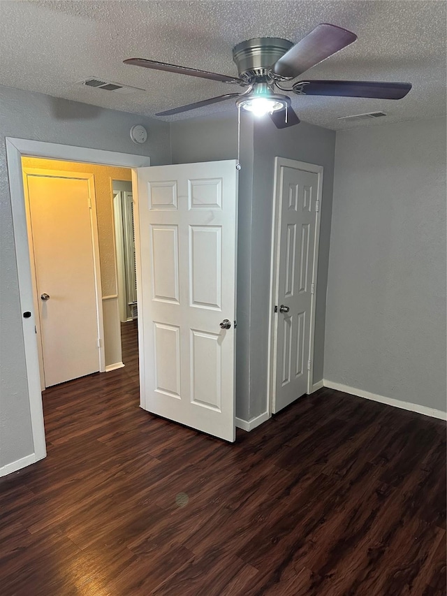 interior space with ceiling fan, dark hardwood / wood-style floors, and a textured ceiling