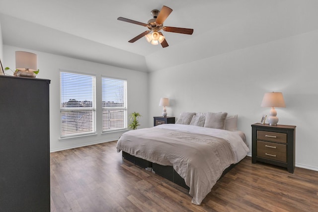 bedroom featuring dark hardwood / wood-style floors, vaulted ceiling, and ceiling fan