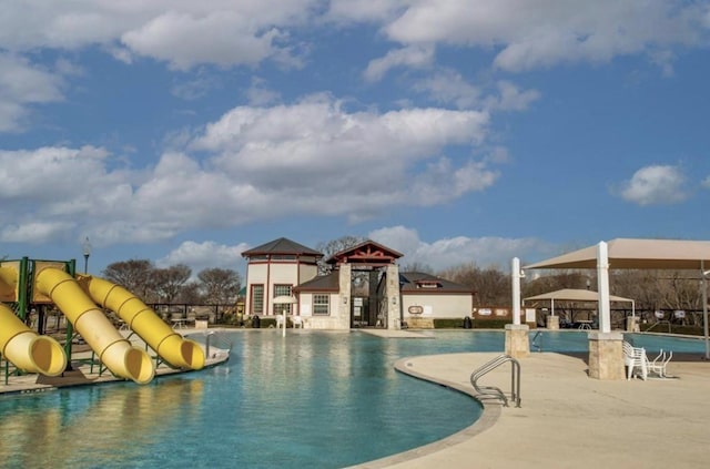 view of pool with a playground and a water slide