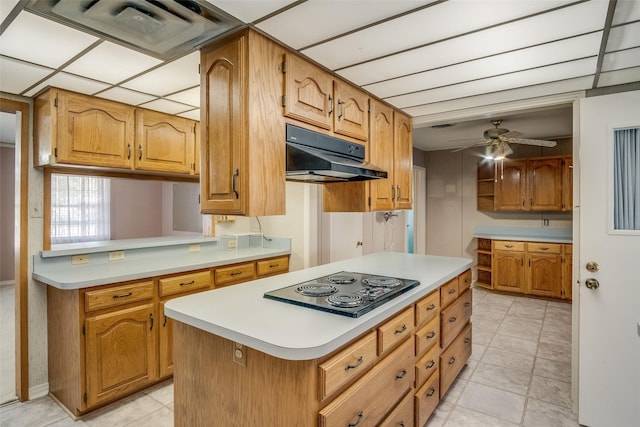 kitchen featuring ceiling fan, black electric stovetop, and a kitchen island