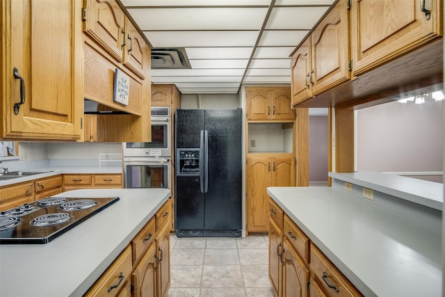 kitchen featuring sink, black appliances, and light tile patterned floors