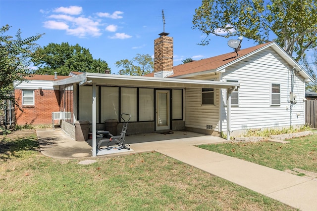 rear view of house featuring a patio area and a yard